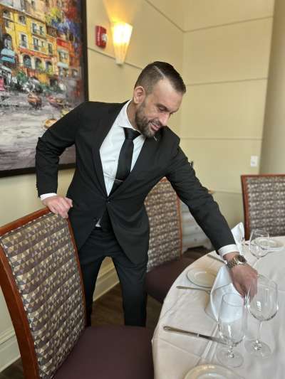 Man, Black Suit, Beard, setting a dining room table