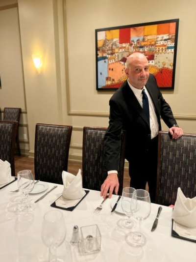 Man Dark Suit Fixing a place setting on a table