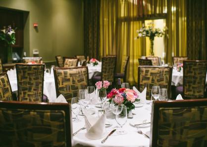 Room set with round tables, white tablecloths, and pink floral centerpieces