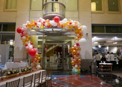 A colorful arch of red, pink, yellow, and white balloons surrounds the entrance to the Galleria lobby space