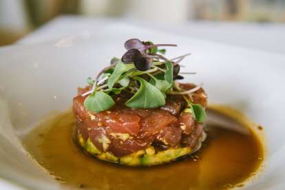 Tuna tartare with avocado and microgreens in a soy mustard sauce