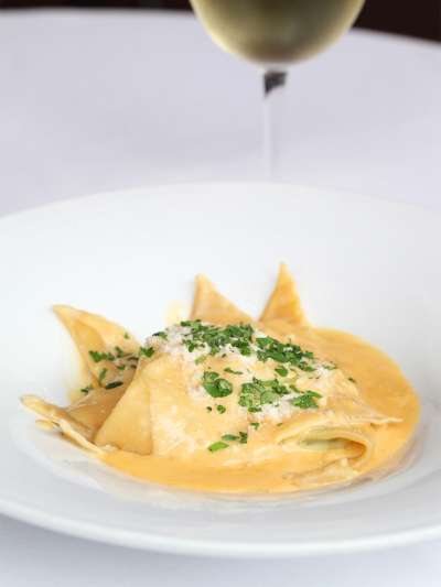 Lemon Ricotta Ravioli with Lemon Butter Sauce served with a glass of white wine