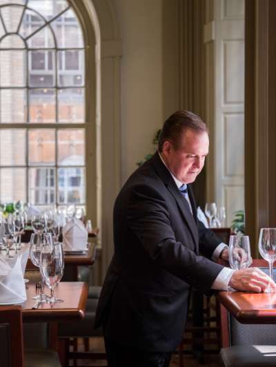 Man, dark suit, at table