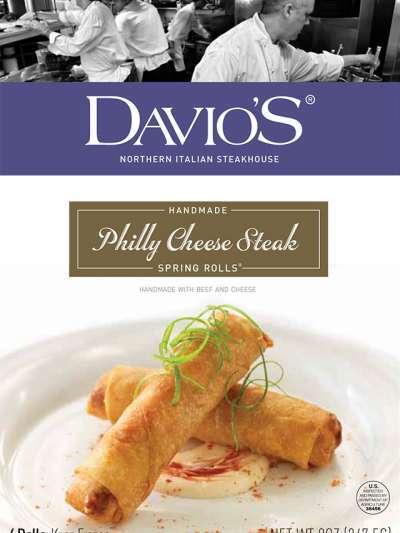 Davio's Philly Cheese Steak Rolls box front shows two spring rolls crossed on a plate over a bed of spicy mayo, above is the Davio's logo on a purple stripe and "Philly Cheese Steak Handmade Spring Rolls" in a cusrive font. The top portion of the box shows a black and white photo of Davio's chefs working in the kitchen.