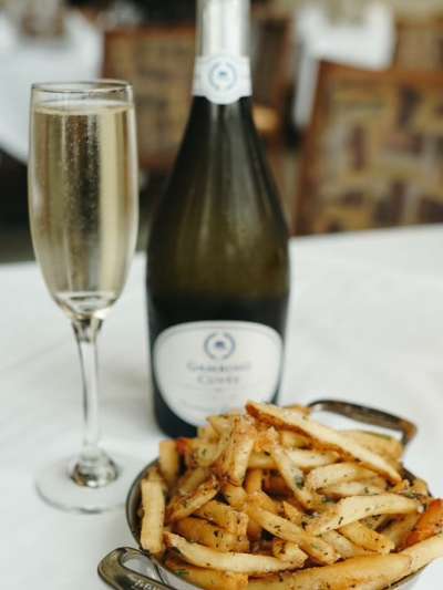 Bottle of Champagne, Glass of Champagne and plate of Fries