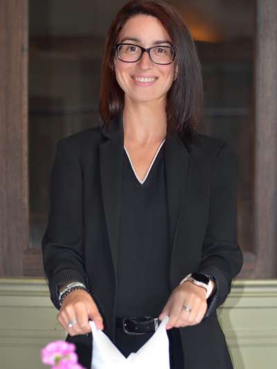 Woman, Dark Hair, Dark Jacket, Fixing a napkin on a table
