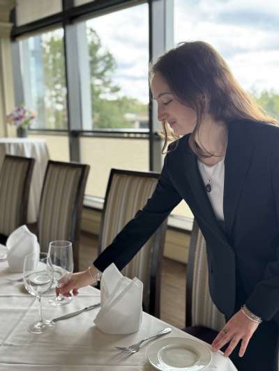 Woman, Dark Hair, fixing a place setting on a table