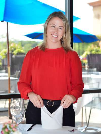 Woman, Blond Hair, Red Shirt, Black Pants, Setting up a napkin on a table