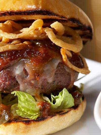 Steakhouse burger, Vermont cheddar, crispy onion rings, herb aioli, on brioche, with fries