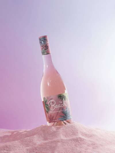 Bottle of Rosé Beach Wine in a pile of sand