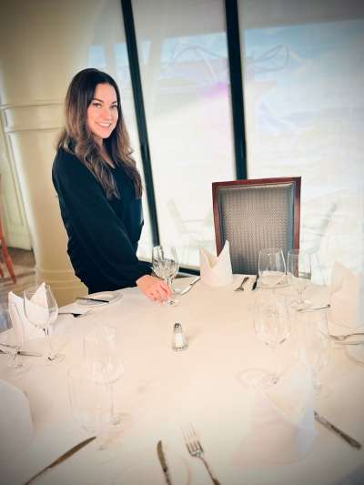 Woman, Dark Hair, Dark Jacket, Fixing a glass on a table