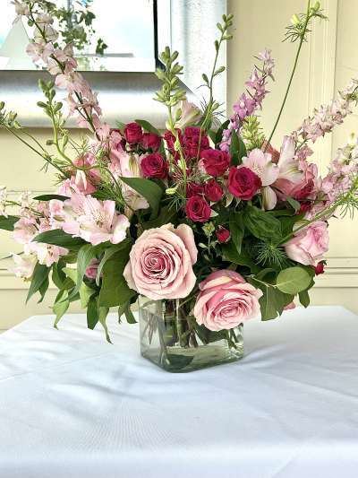 Pink, White Rosé roses and flowers in a vase on a table