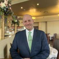 Man Green Tie, Blue Suit Leaning on a chair