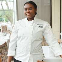 Woman, White Chef Coat, Dark Hair, Standing in Dining room