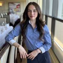 Woman, Long, Dark Hair, Blue Shirt, leaning on the bar