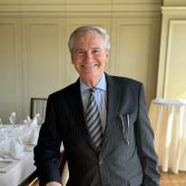 Man Dark Suit leaning on a chair
