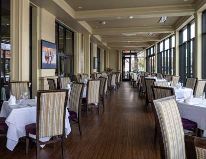 Square tables in a long room with Floor to Ceiling Glass Windows