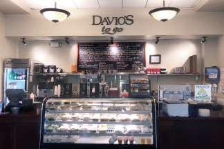 Davio's Boston To Go Shop features hot coffee, soup and cookies behind the counter, a refrigerated case with salads and sandwiches, and a chalkboard overhead detailing the daily specials