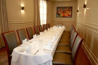 A long table with a white tablecloth, set for 18
